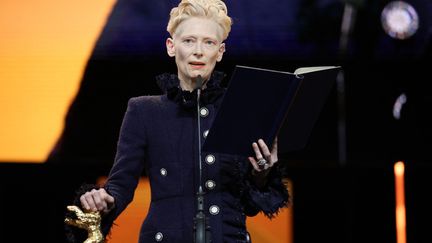 L'actrice écossaise Tilda Swinton prononce un discours après avoir reçu l'Ours d'honneur de la Berlinale lors de la cérémonie d'ouverture précédant la projection du film "The Light" (La Lumière) dans la section spécial Berlinale du 75e festival du film européen de l'année, à Berlin, le 13 février 2025. (RONNY HARTMANN / AFP)